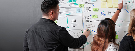 Graphic Designer drawing website wireframes on white board